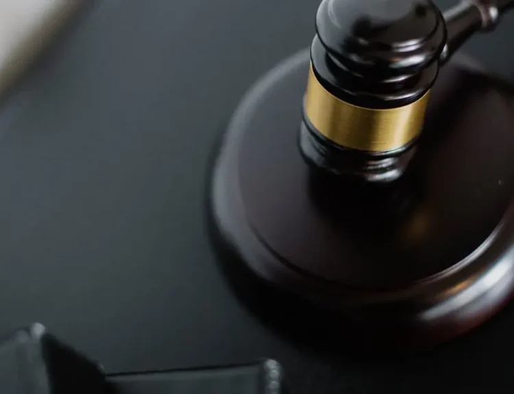 Close-up of a wooden judge's gavel on a black desk, symbolizing justice and law.